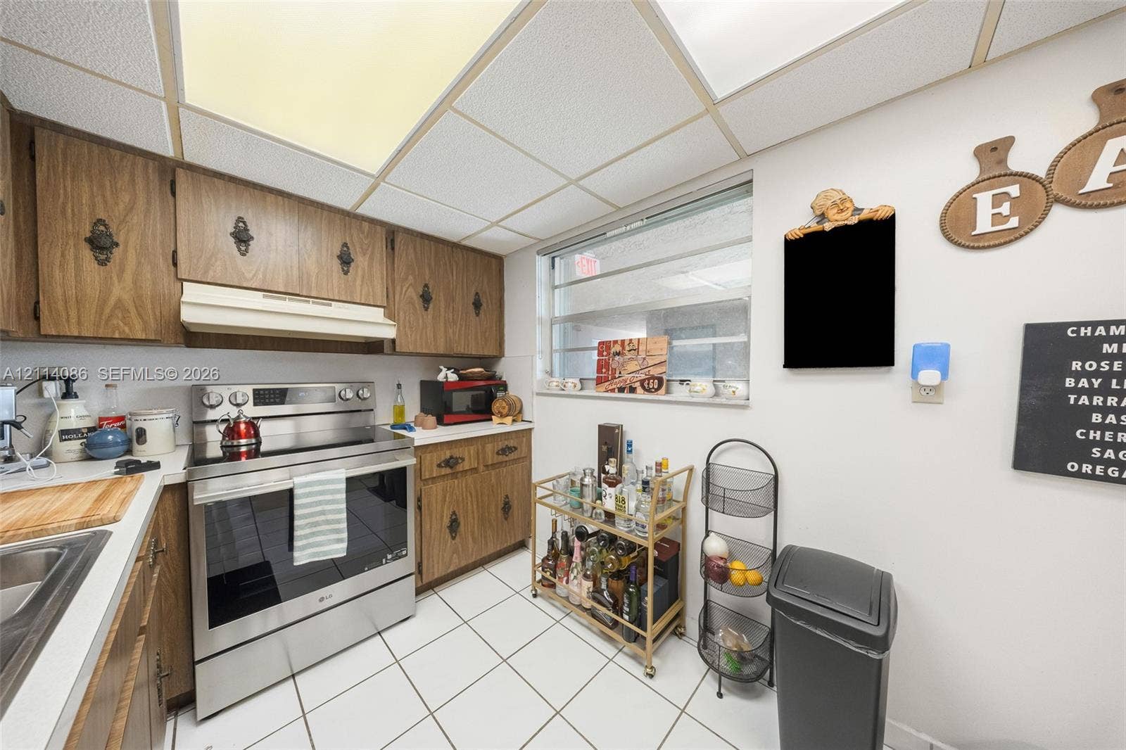 706 NW 87th Avenue, #204, Miami, Miami, FL 33172 Kitchen featuring wood-finish cabinetry, stainless steel range, drop-in sink, and ceramic tile flooring