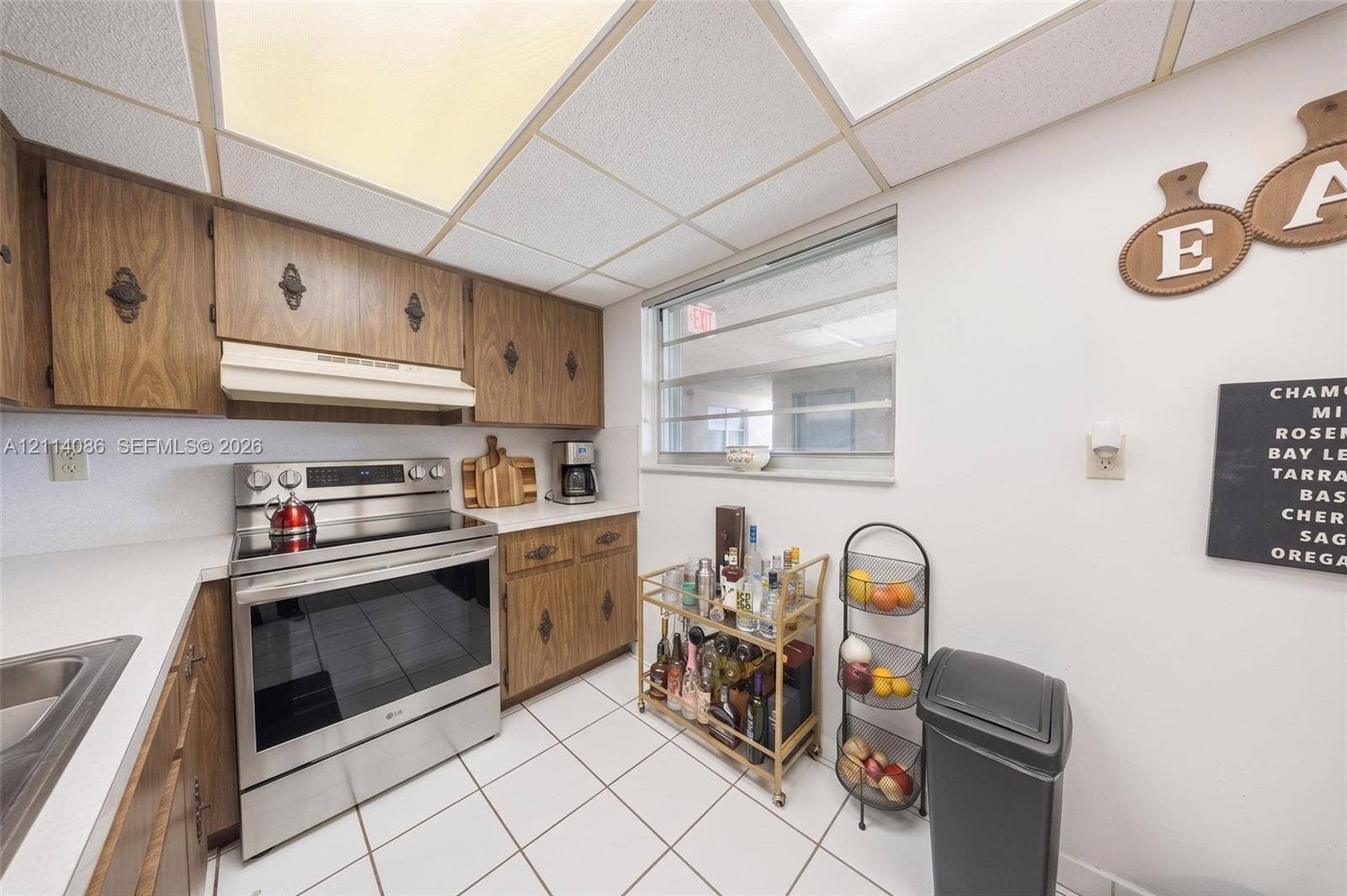 706 NW 87th Avenue, #204, Miami, Miami, FL 33172 Kitchen featuring wood cabinetry, stainless steel range with overhead vent hood, ceramic tile flooring, and integrated drop-in sink