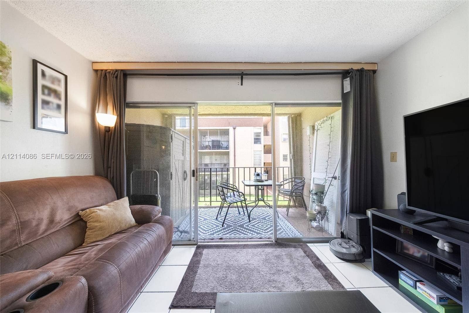 706 NW 87th Avenue, #204, Miami, Miami, FL 33172 Sliding glass doors opening to a private balcony with metal railing and tile flooring