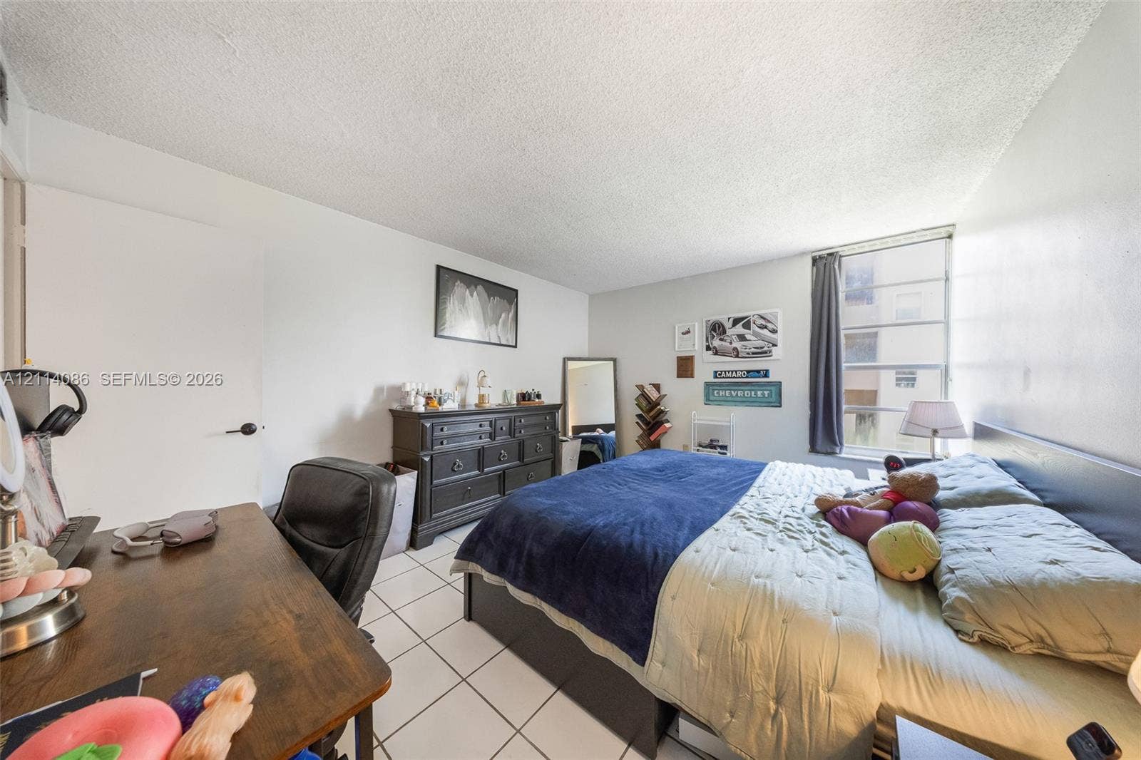 706 NW 87th Avenue, #204, Miami, Miami, FL 33172 Bedroom featuring white tile flooring, neutral walls, and a large multi-pane window