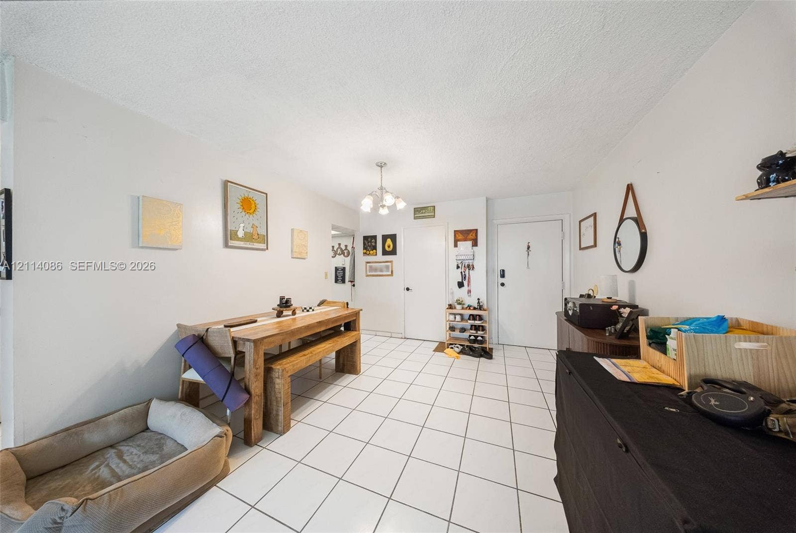 706 NW 87th Avenue, #204, Miami, Miami, FL 33172 Neutral-tone interior featuring white ceramic tile flooring and a multi-arm chandelier