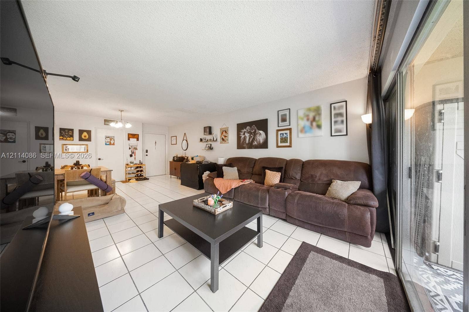 706 NW 87th Avenue, #204, Miami, Miami, FL 33172 Open-concept living space featuring large-format ceramic tile flooring, sliding glass door, and recessed lighting
