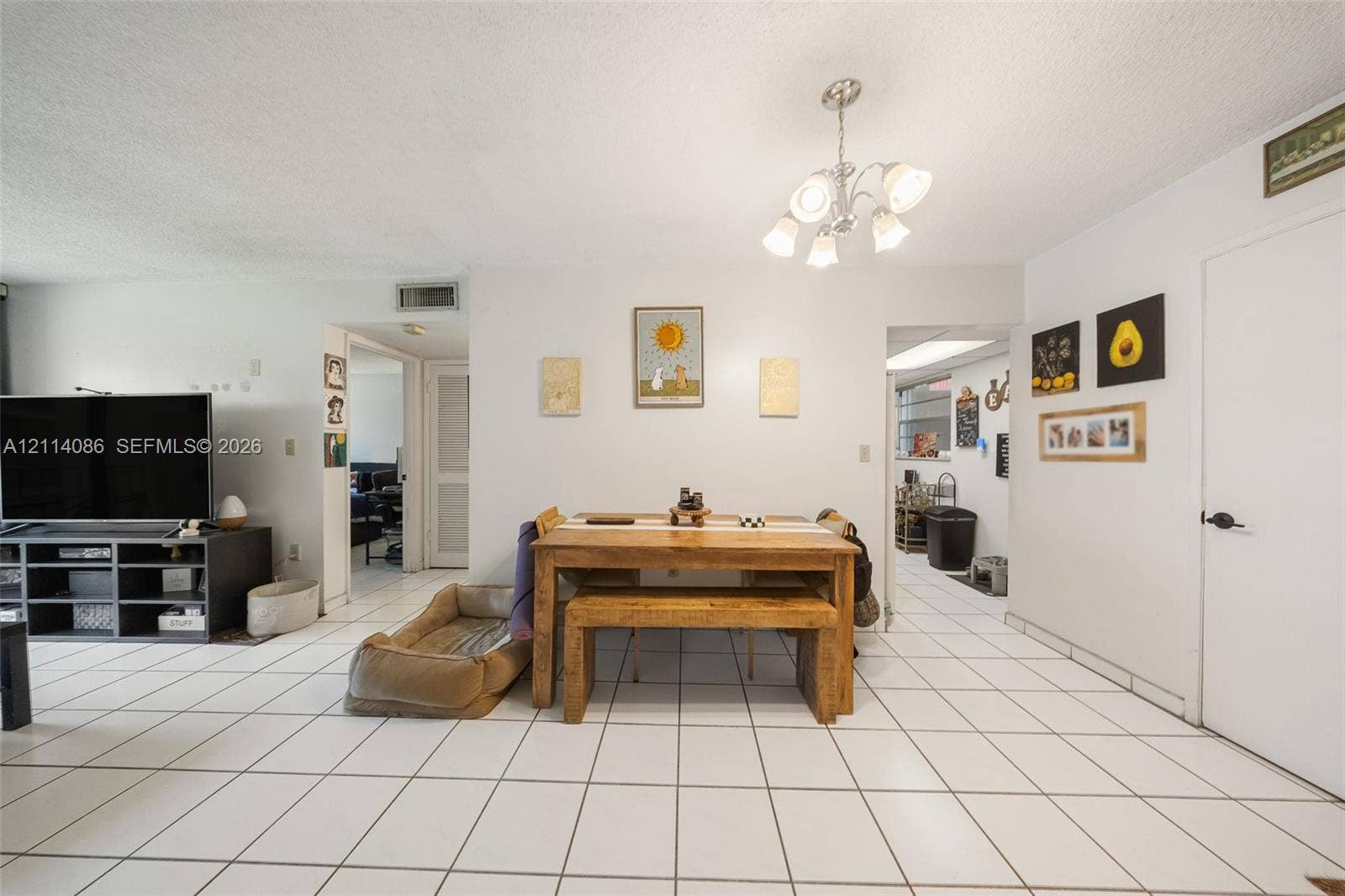 706 NW 87th Avenue, #204, Miami, Miami, FL 33172 Open-concept area featuring white ceramic tile flooring and a multi-arm polished metal chandelier