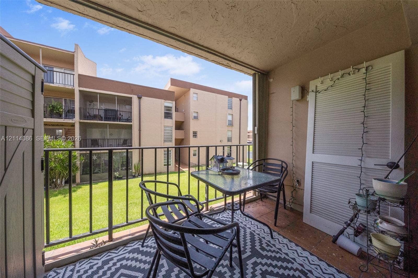706 NW 87th Avenue, #204, Miami, Miami, FL 33172 Covered balcony featuring tile flooring, metal railings, and integrated exterior storage