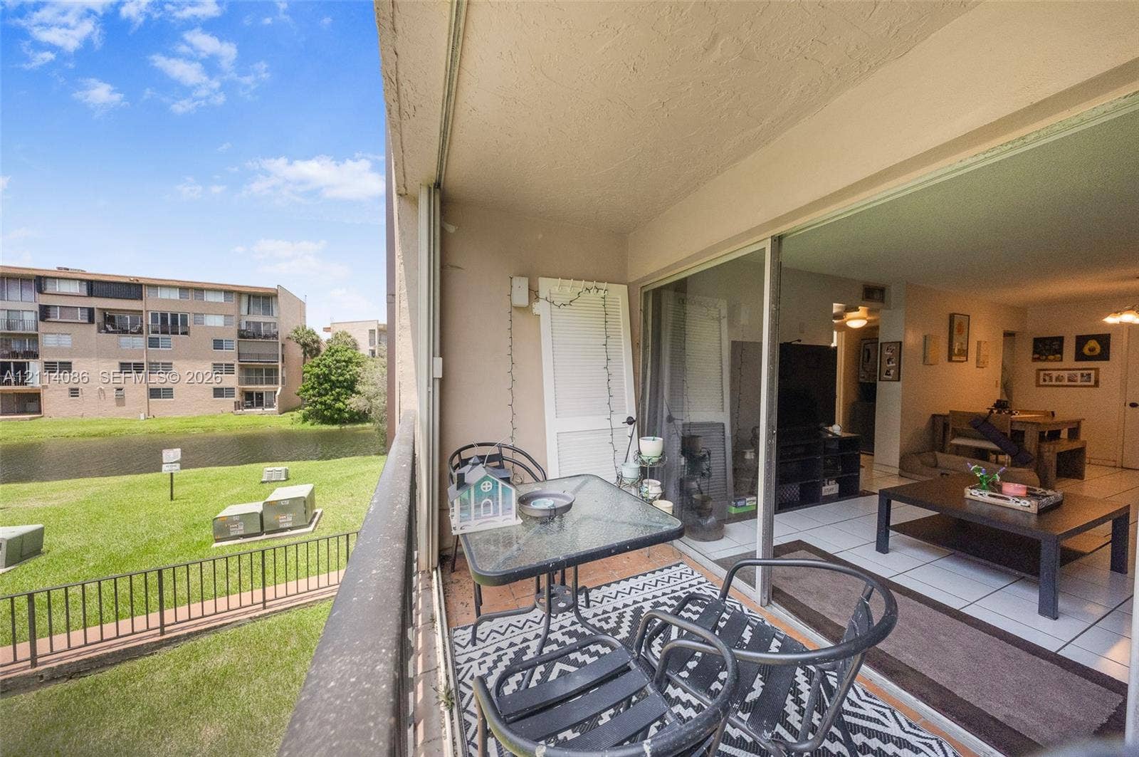 706 NW 87th Avenue, #204, Miami, Miami, FL 33172 Covered balcony with metal railing, sliding glass doors, and water-facing exterior exposure