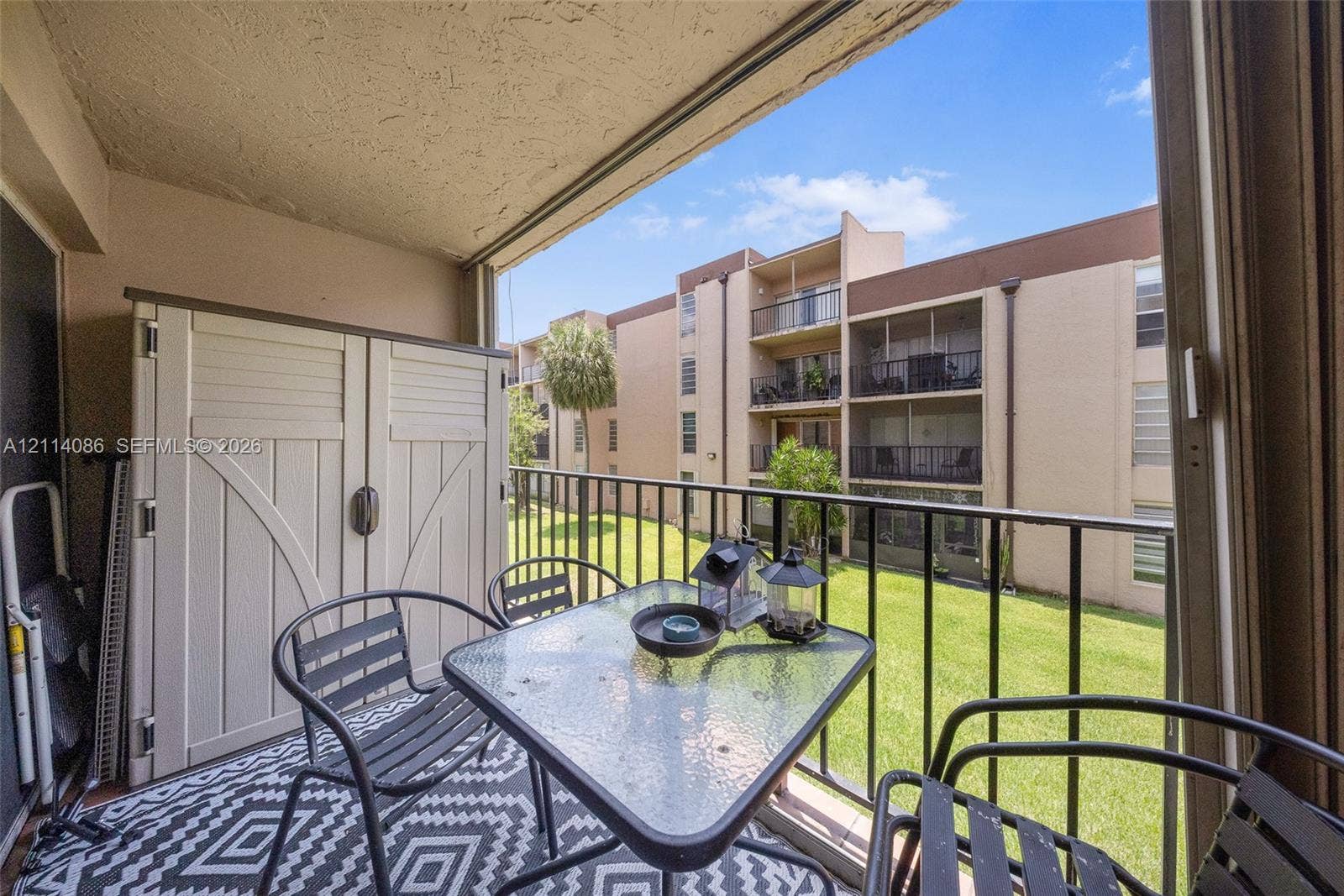 706 NW 87th Avenue, #204, Miami, Miami, FL 33172 Covered balcony featuring a metal railing and built-in storage unit