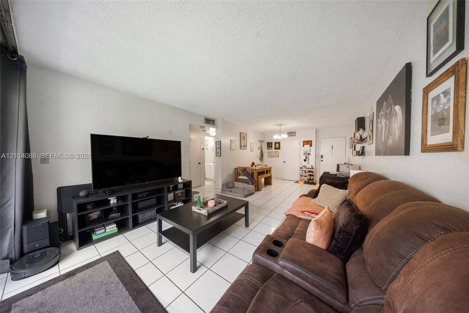 706 NW 87th Avenue, #204, Miami, Miami, FL 33172 Living area featuring large format tile flooring, neutral wall paint, and overhead lighting fixtures