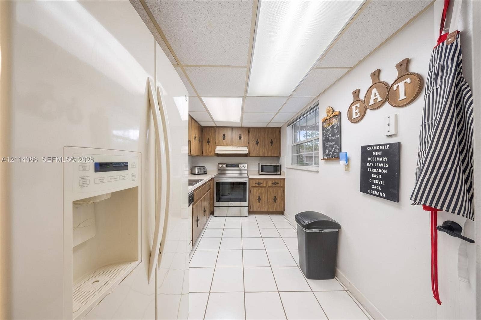 706 NW 87th Avenue, #204, Miami, Miami, FL 33172 Kitchen featuring stainless steel appliances, stained wood cabinetry, ceramic tile flooring, and integrated lighting