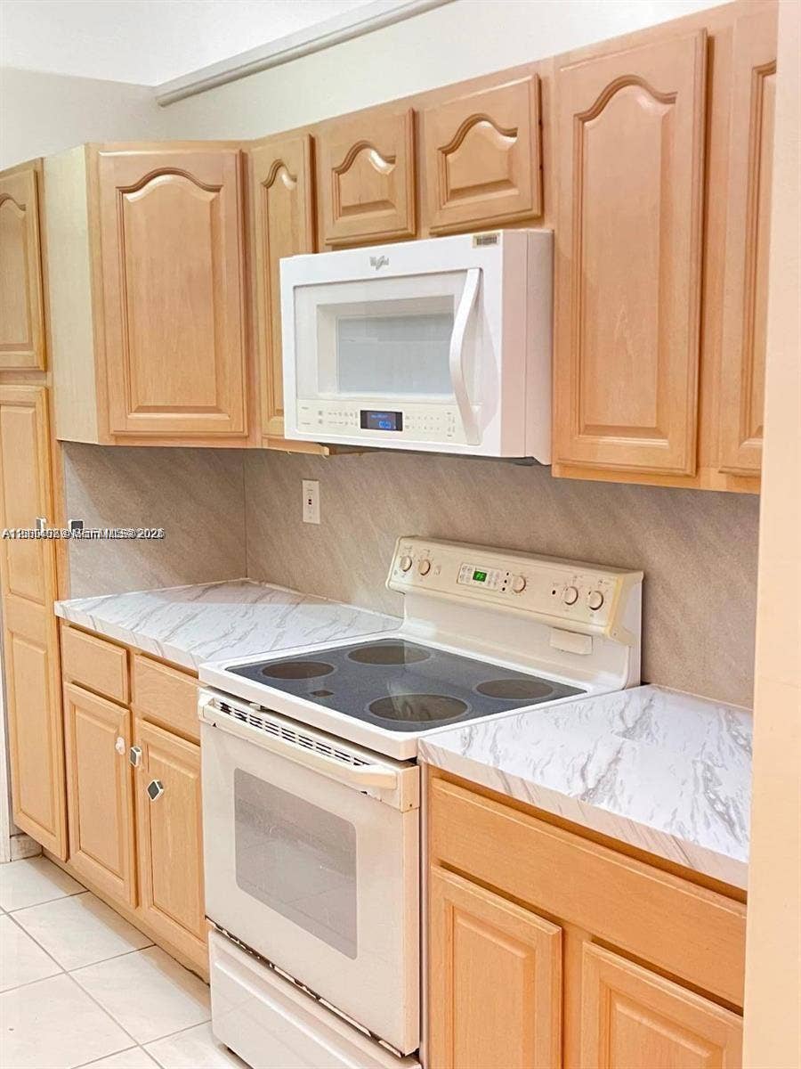 17220 SW 93rd Avenue, #0, Palmetto Bay, Palmetto Bay, FL 33157 Kitchen featuring natural wood-finish cabinetry, stone-patterned laminate countertops, tile backsplash, and white appliance package