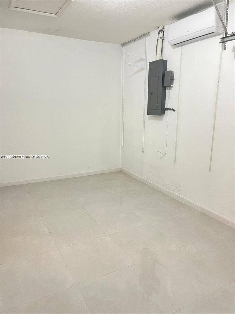 17220 SW 93rd Avenue, #0, Palmetto Bay, Palmetto Bay, FL 33157 Enclosed space featuring large-format ceramic tile flooring, a mounted ductless mini-split climate control unit, and wall-mounted electrical panel