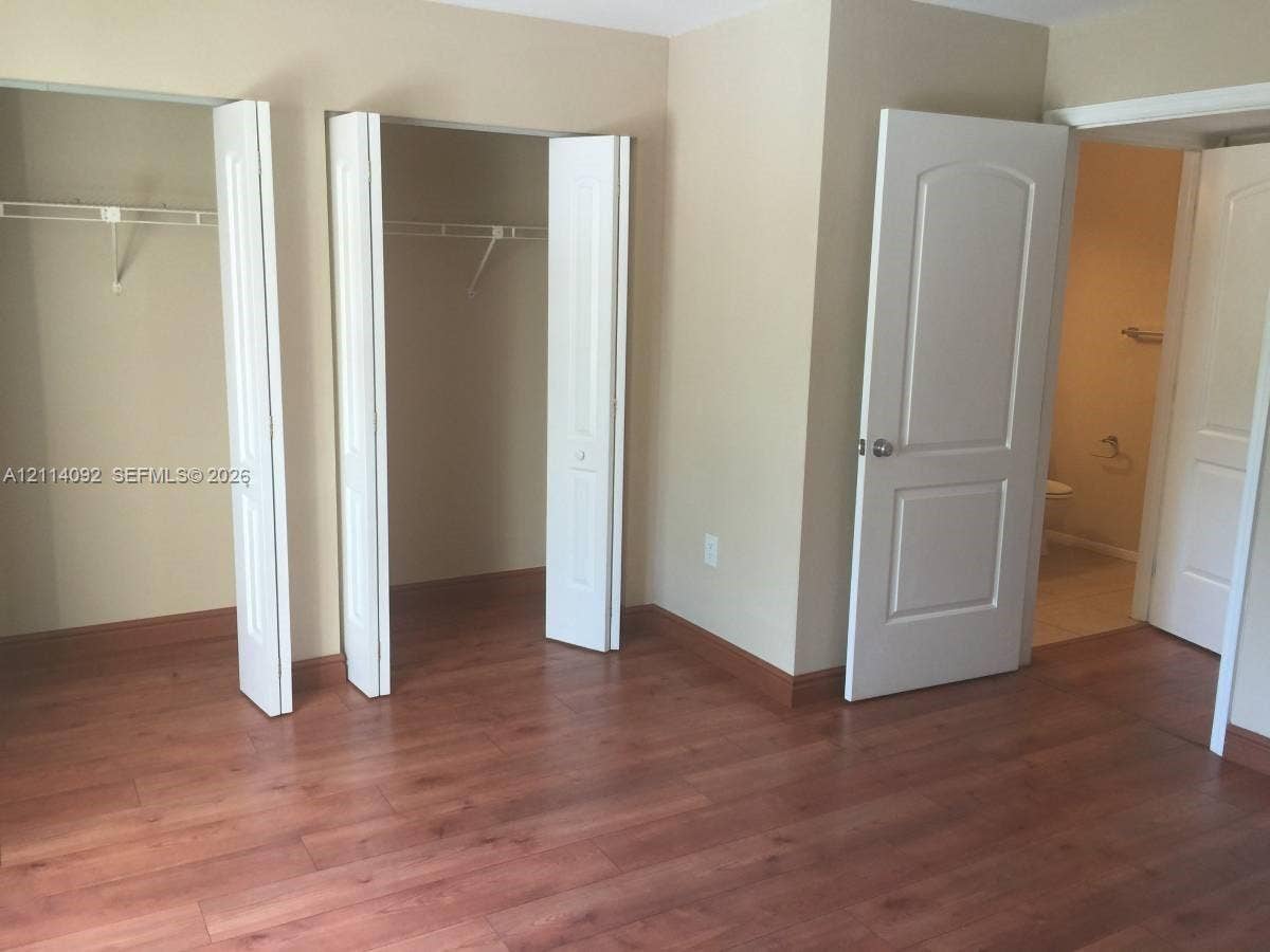 2667 NW 33rd Street, #2413, Oakland Park, Oakland Park, FL 33309 Wood-finish flooring, dual bi-fold door closets with integrated shelving, and two-panel interior doors