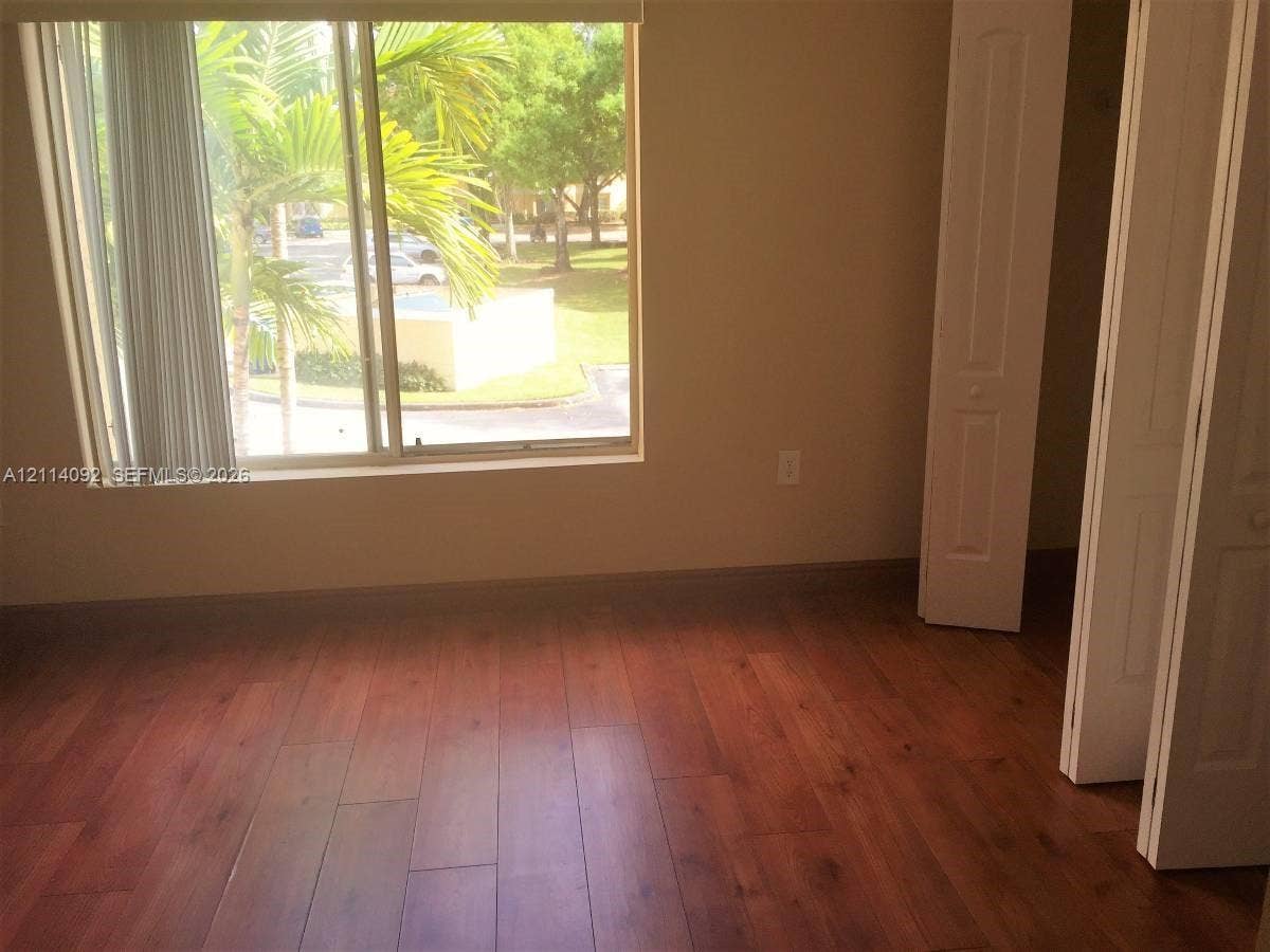 2667 NW 33rd Street, #2413, Oakland Park, Oakland Park, FL 33309 Wood-finish flooring, sliding glass window with neutral blinds, and dual-panel closet doors