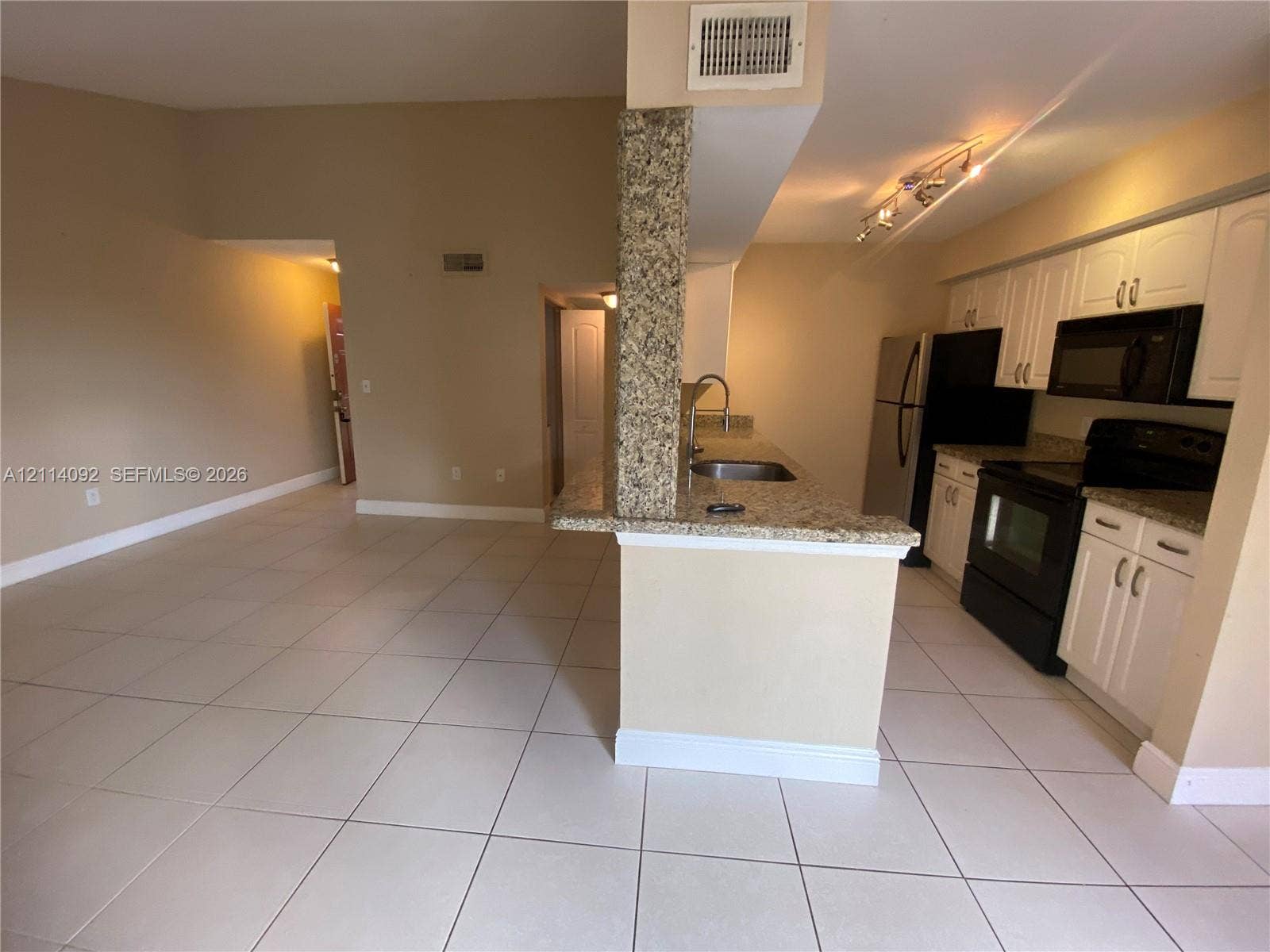 2667 NW 33rd Street, #2413, Oakland Park, Oakland Park, FL 33309 Kitchen featuring white cabinetry, stone-finish countertops, tile flooring, and integrated track lighting