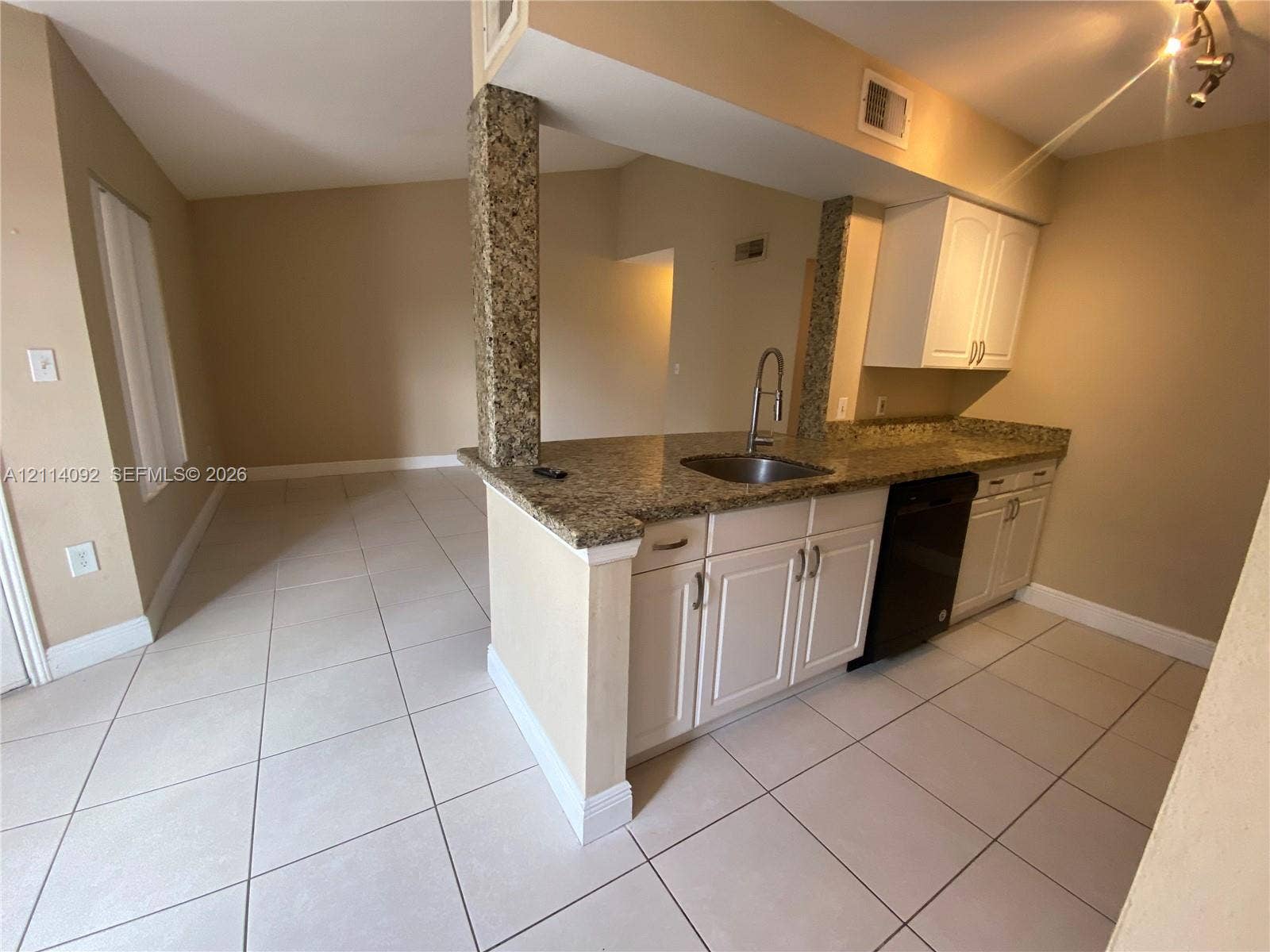 2667 NW 33rd Street, #2413, Oakland Park, Oakland Park, FL 33309 Kitchen featuring white cabinetry, stone-surface countertops, tile flooring, a stainless steel sink with a high-arch faucet, and an integrated dishwasher
