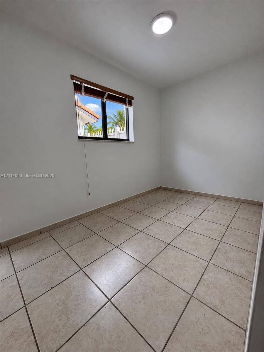 4916 SW 142nd Place, #4916, Miami, Miami, FL 33175 Neutral-toned tile flooring, white wall finishes, flush-mount ceiling lighting, and a single-pane window with a wooden valance