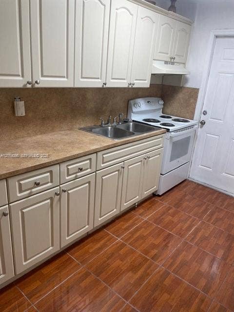 14180 NW 22nd Court, #0, Opa Locka, Opa Locka, FL 33054 Kitchen featuring neutral-toned cabinetry, dual-basin stainless steel sink, tile-finish flooring, and a built-in range hood