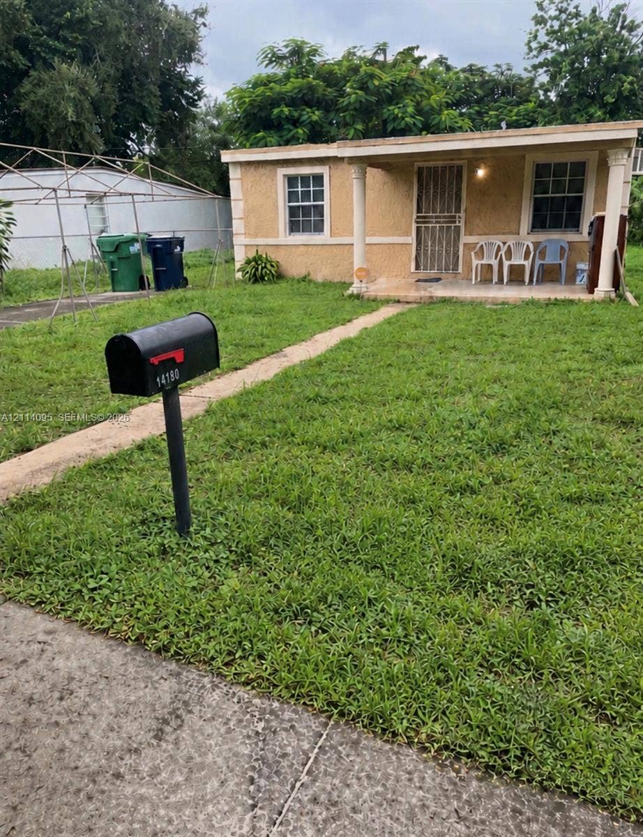 14180 NW 22nd Court, #0, Opa Locka, Opa Locka, FL 33054 Single-story exterior featuring a textured stucco finish, front covered porch with classical columns, and multi-pane windows