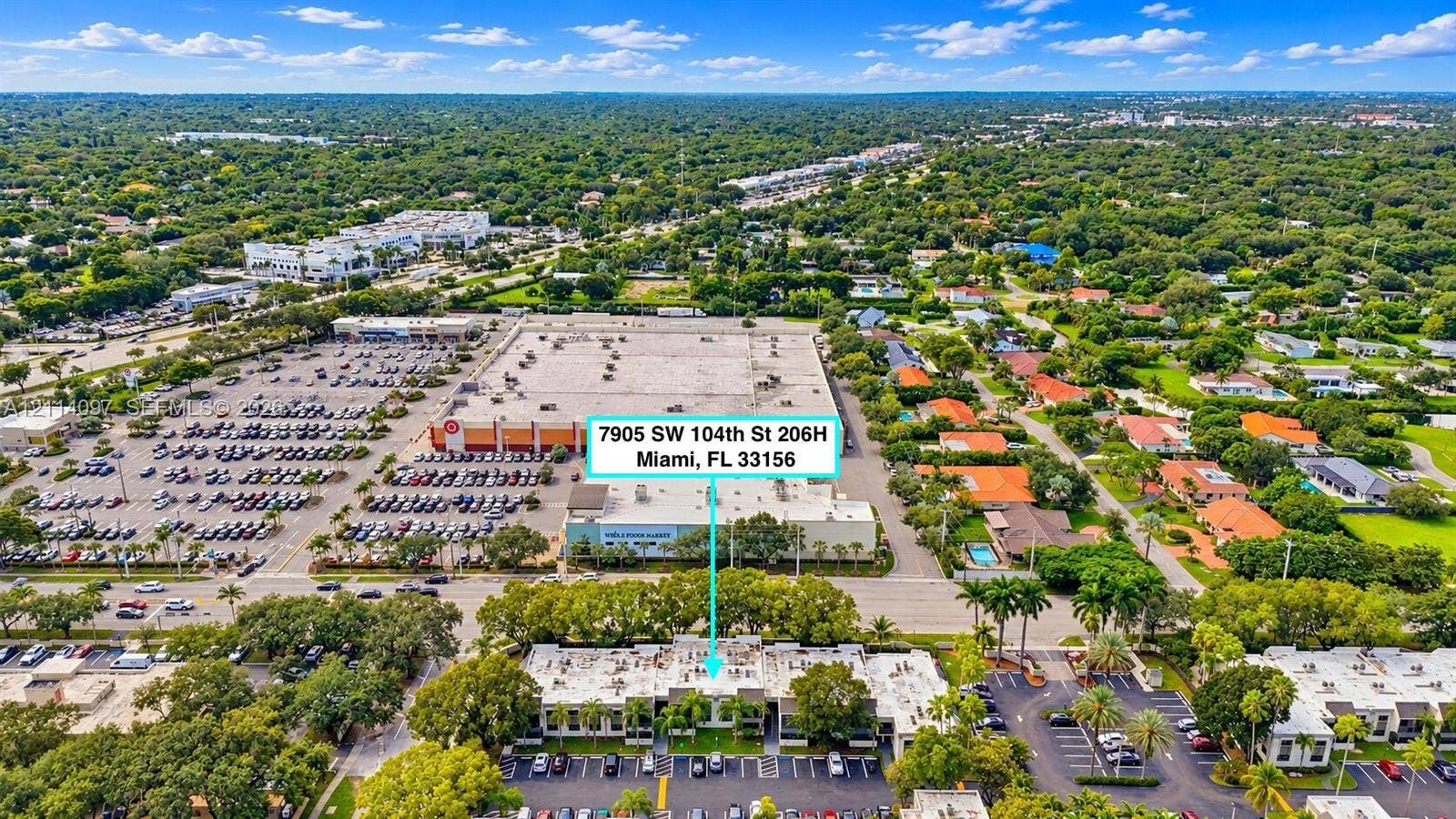 7905 SW 104th Street, #206H, Miami, FL 33156 Aerial perspective of a multi-unit complex featuring exterior parking areas, low-rise architecture, and mature trees situated in a developed urban area