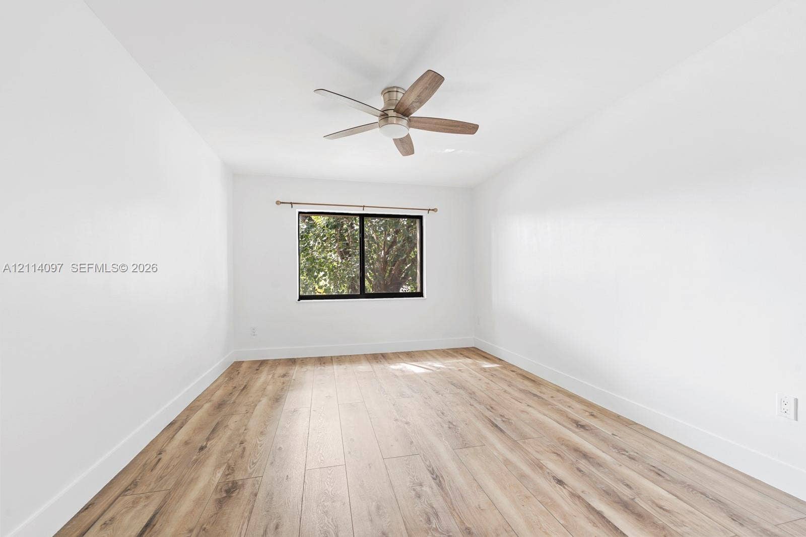 7905 SW 104th Street, #206H, Miami, FL 33156 Neutral interior featuring wood-finish flooring, a ceiling fan with integrated lighting, and a window with a dark frame