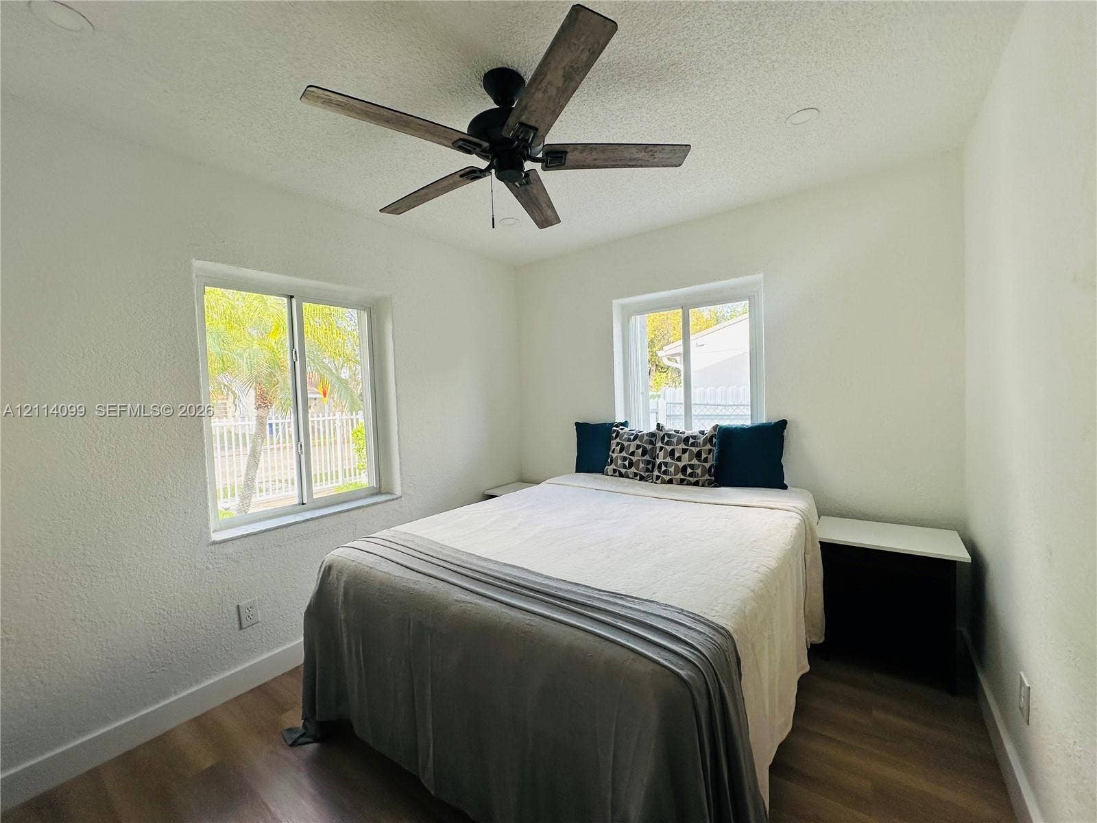 3052 SW 6th Street, Miami, FL 33135 Room featuring wood-finish flooring, recessed lighting, dual windows, and a ceiling fan with dark wood-toned blades