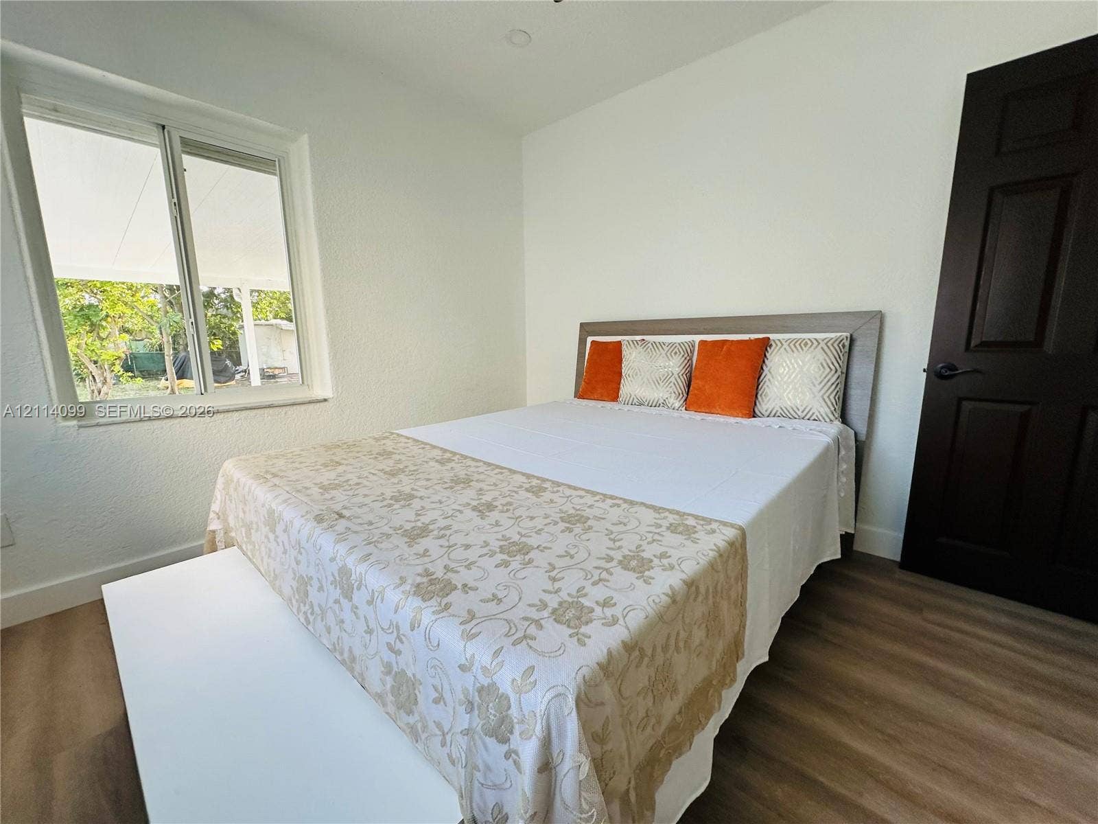 3052 SW 6th Street, Miami, FL 33135 Wood-finish flooring, dual-pane window, and solid core door with matte black hardware