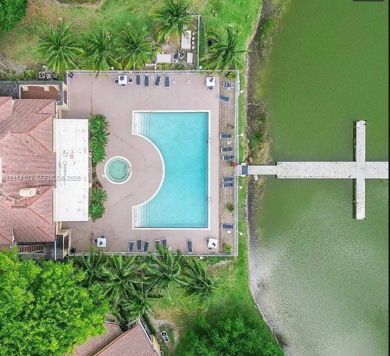 2485 NW 33rd Street, #1602, Oakland Park, Oakland Park, FL 33309 Aerial perspective of an expansive pool deck featuring a geometric swimming pool, integrated spa, tiled patio, and private boat dock extending into the water
