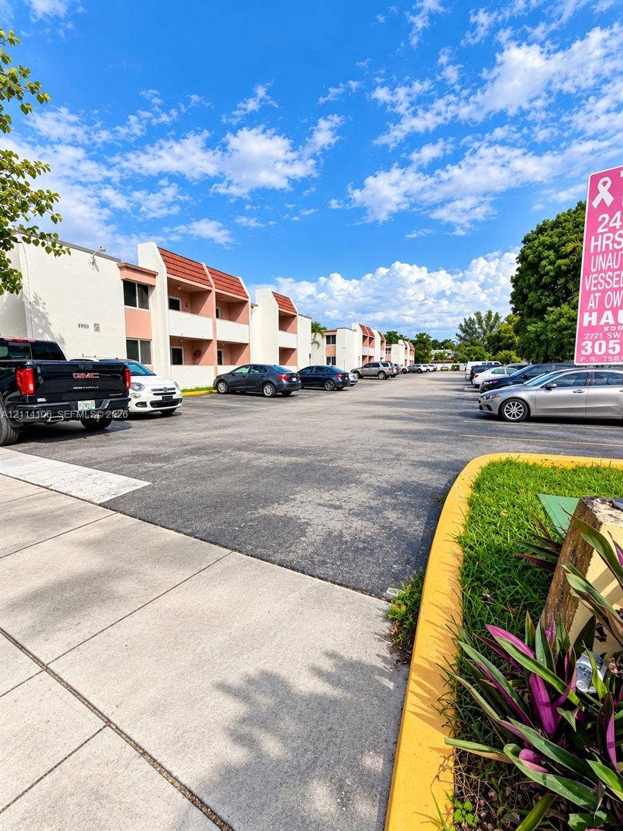 8990 SW 24th Street, #214, Miami, FL 33165 Asphalt-paved surface lot featuring marked parking stalls and concrete curbing