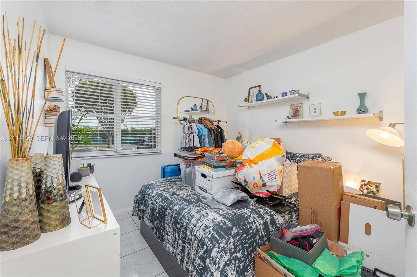 15761 SW 137th Avenue, #104, Miami, Miami, FL 33177 Interior space featuring white tile flooring, horizontal window blinds, and two white wall-mounted floating shelves