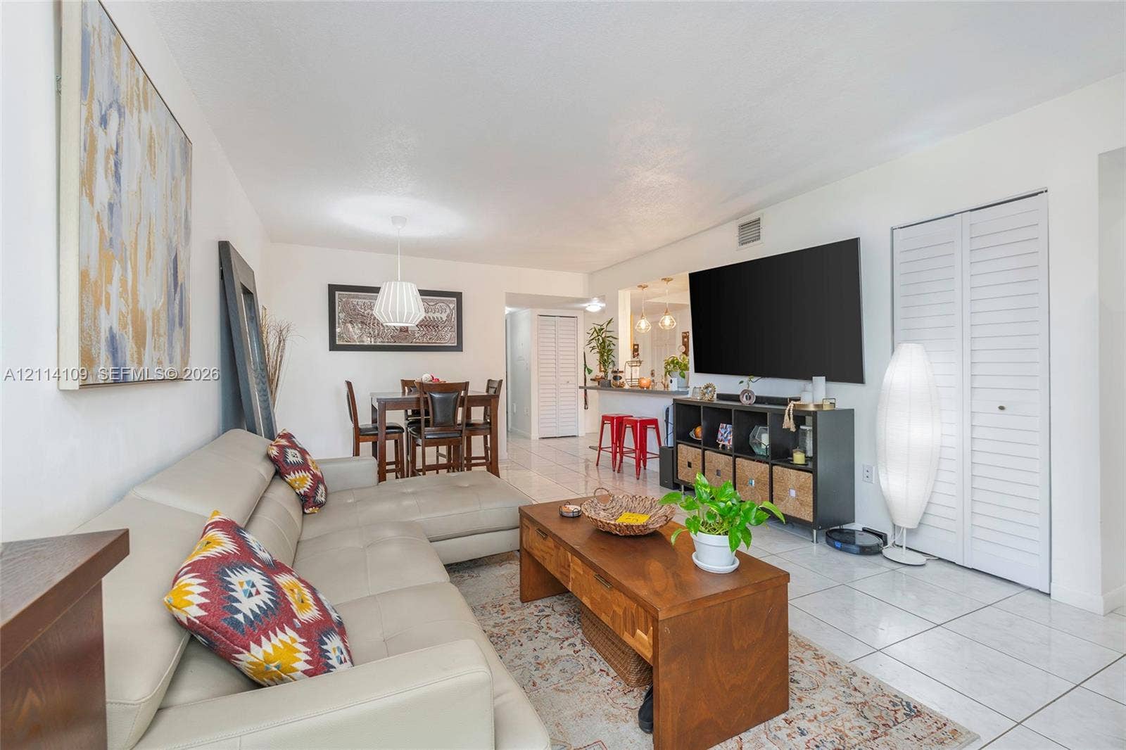 15761 SW 137th Avenue, #104, Miami, Miami, FL 33177 Open-concept interior featuring light-colored floor tiling, recessed lighting, white louvered closet doors, and a breakfast bar counter