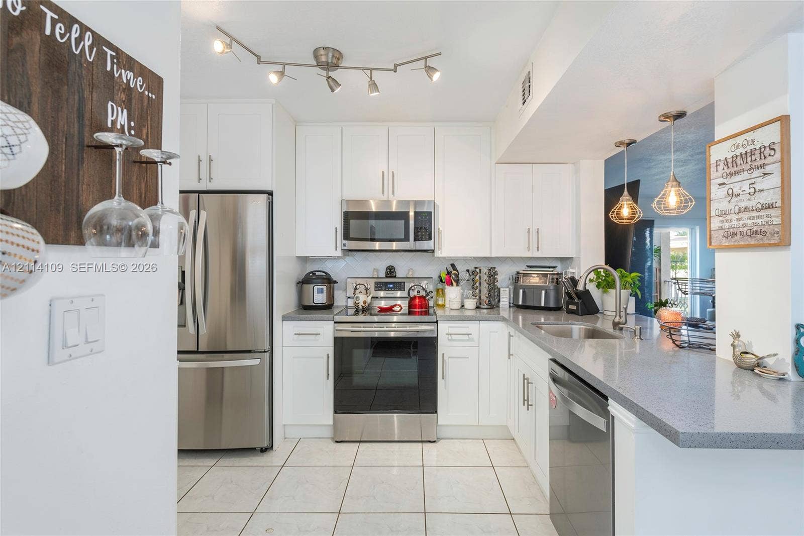 15761 SW 137th Avenue, #104, Miami, Miami, FL 33177 Kitchen featuring white shaker-style cabinetry, stainless steel appliances, grey solid-surface countertops, tile flooring, and adjustable track lighting