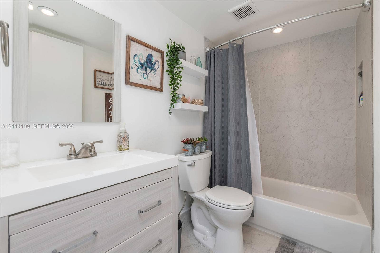 15761 SW 137th Avenue, #104, Miami, Miami, FL 33177 Bathroom featuring a vanity with a white countertop and integrated sink, recessed lighting, wall-mounted shelving, and a tub-shower combination with full-height stone-patterned wall surround and integrated niche
