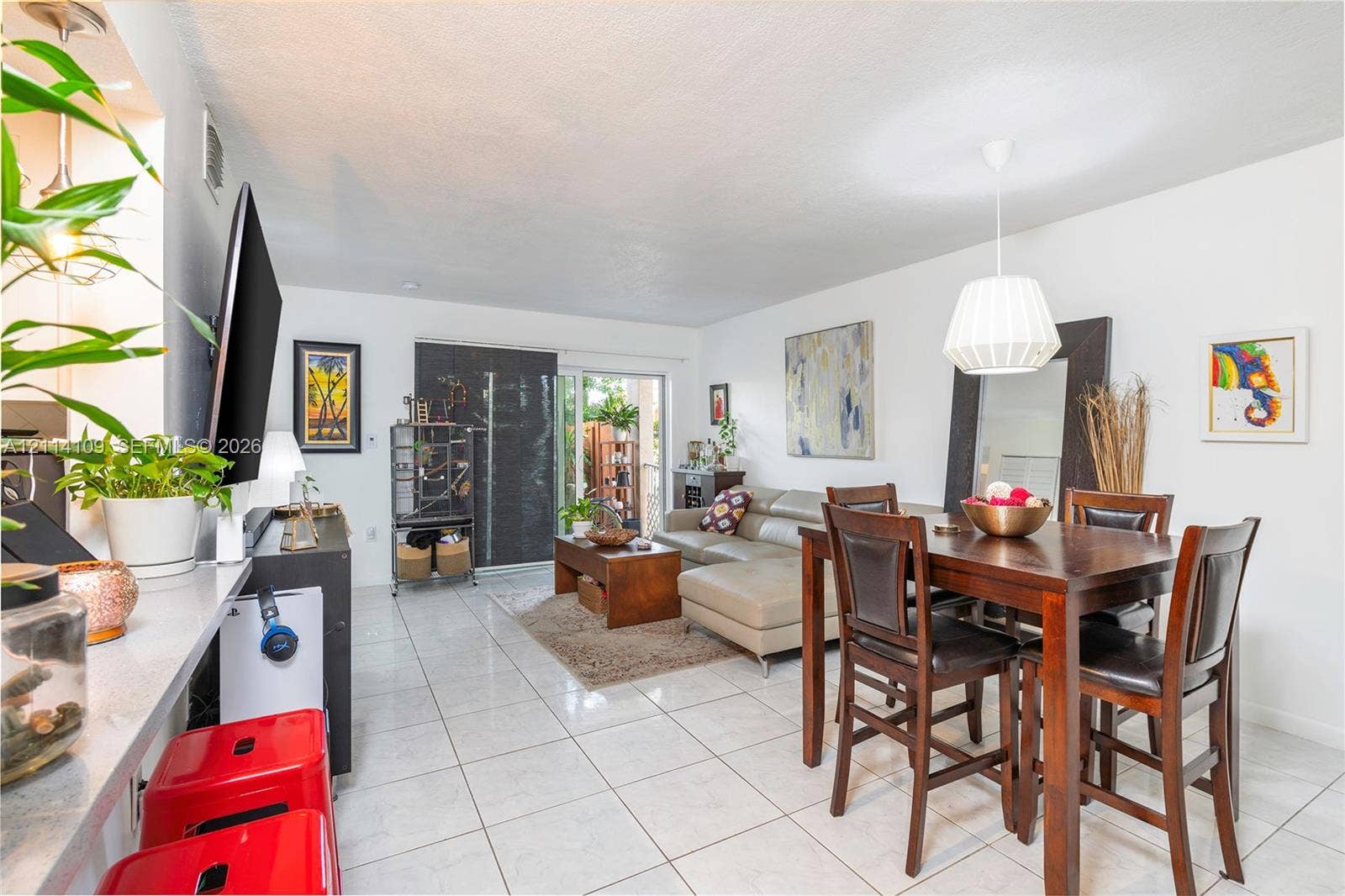 15761 SW 137th Avenue, #104, Miami, Miami, FL 33177 Open-concept floor plan featuring ceramic tile flooring, neutral wall tones, a modern pendant light fixture, and sliding glass doors
