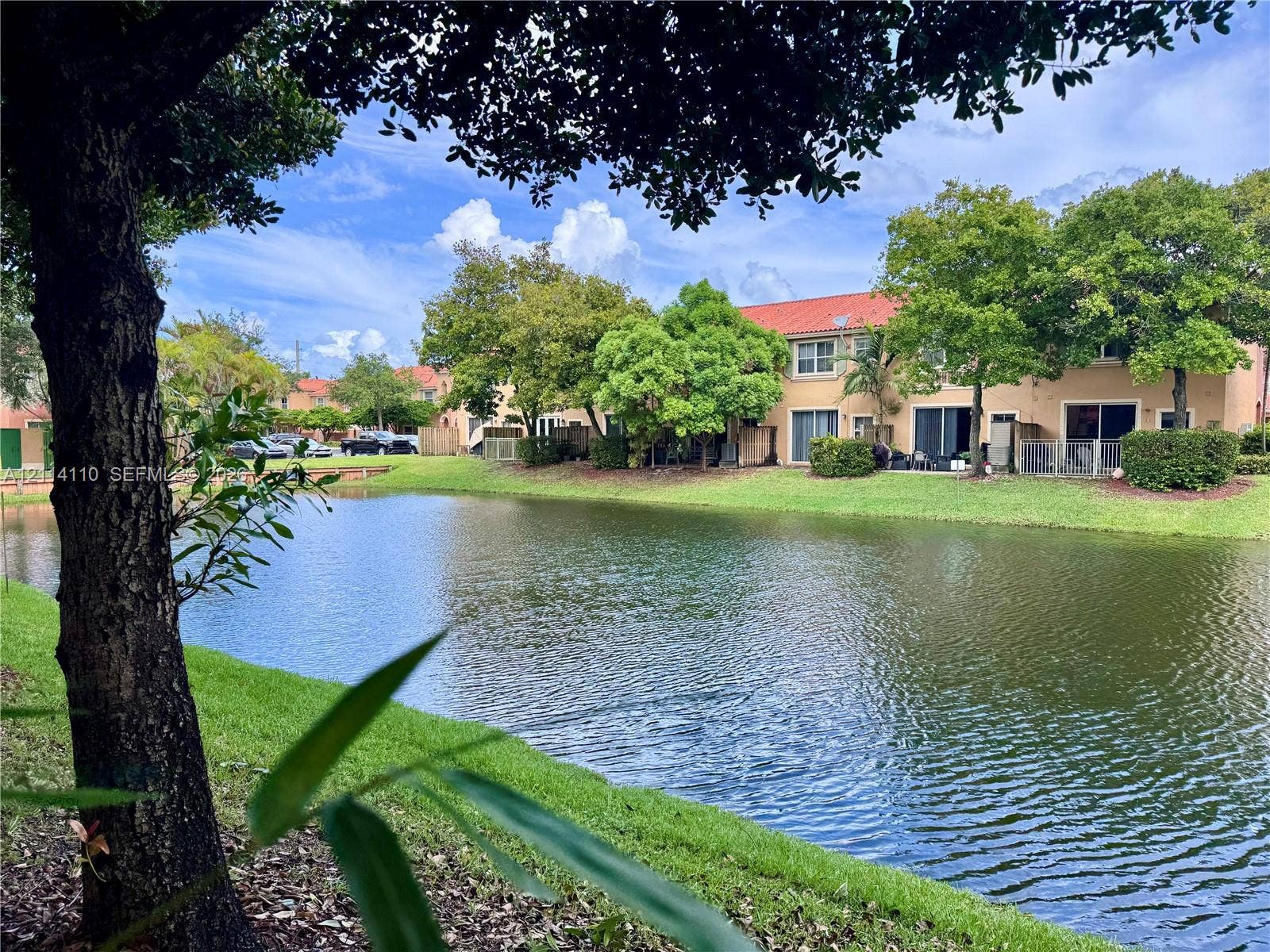 4928 Leeward Lane, #3603, Dania Beach, FL 33312 Waterfront exterior featuring a concrete tile roof, manicured lawn, and mature landscaping