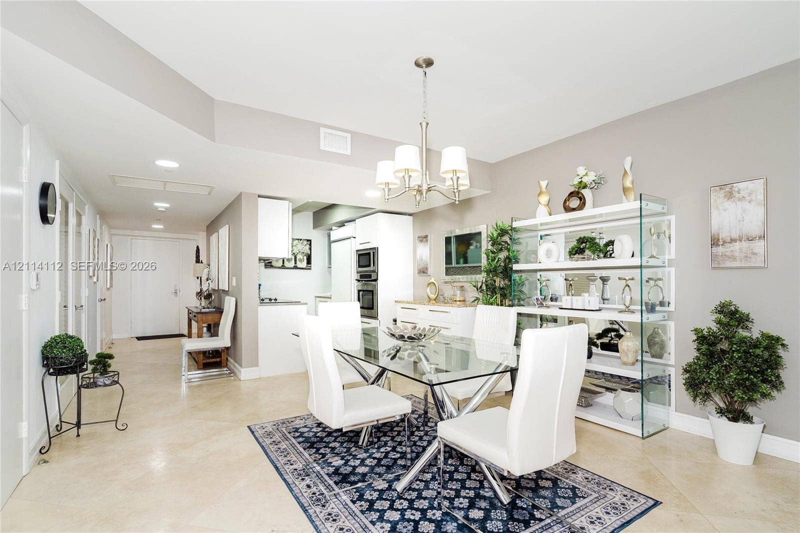 1850 S Ocean Drive, #4008, Hallandale Beach, FL 33009 Open-concept dining area featuring neutral tile flooring, a multi-light metal chandelier, recessed ceiling lighting, and a built-in glass shelving unit