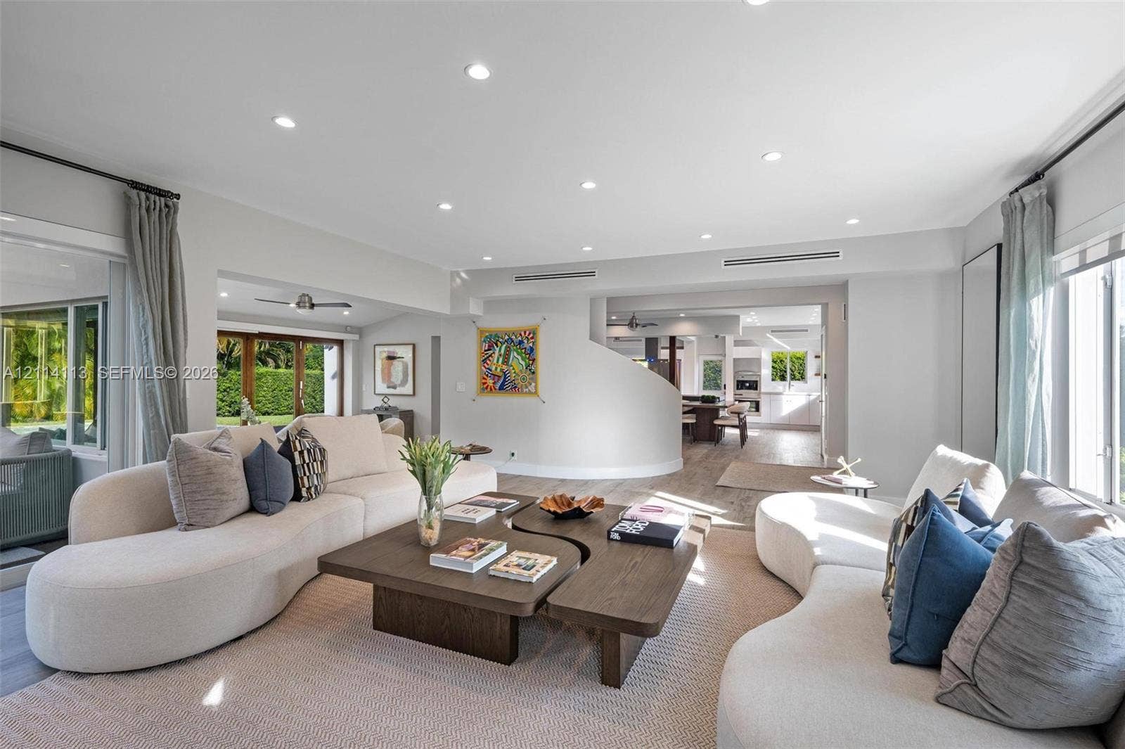 5386 Alton Road, Miami Beach, FL 33140 Open-concept interior featuring recessed lighting, a curved architectural partition wall, neutral wall palette, and wood-finish flooring