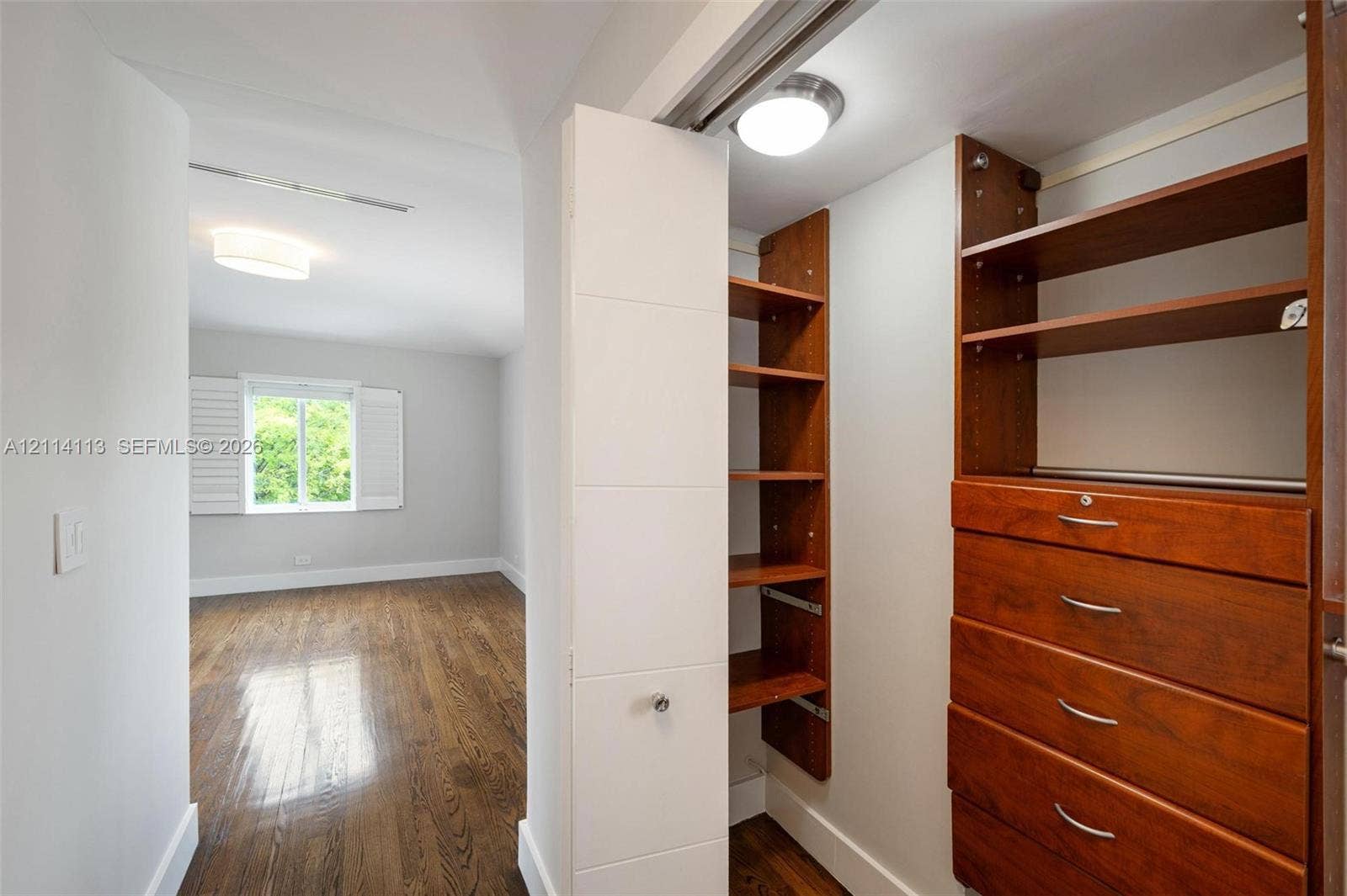 5386 Alton Road, Miami Beach, FL 33140 Custom storage system with wood-finish shelving and built-in drawers, polished metal hardware, and wood-finish flooring