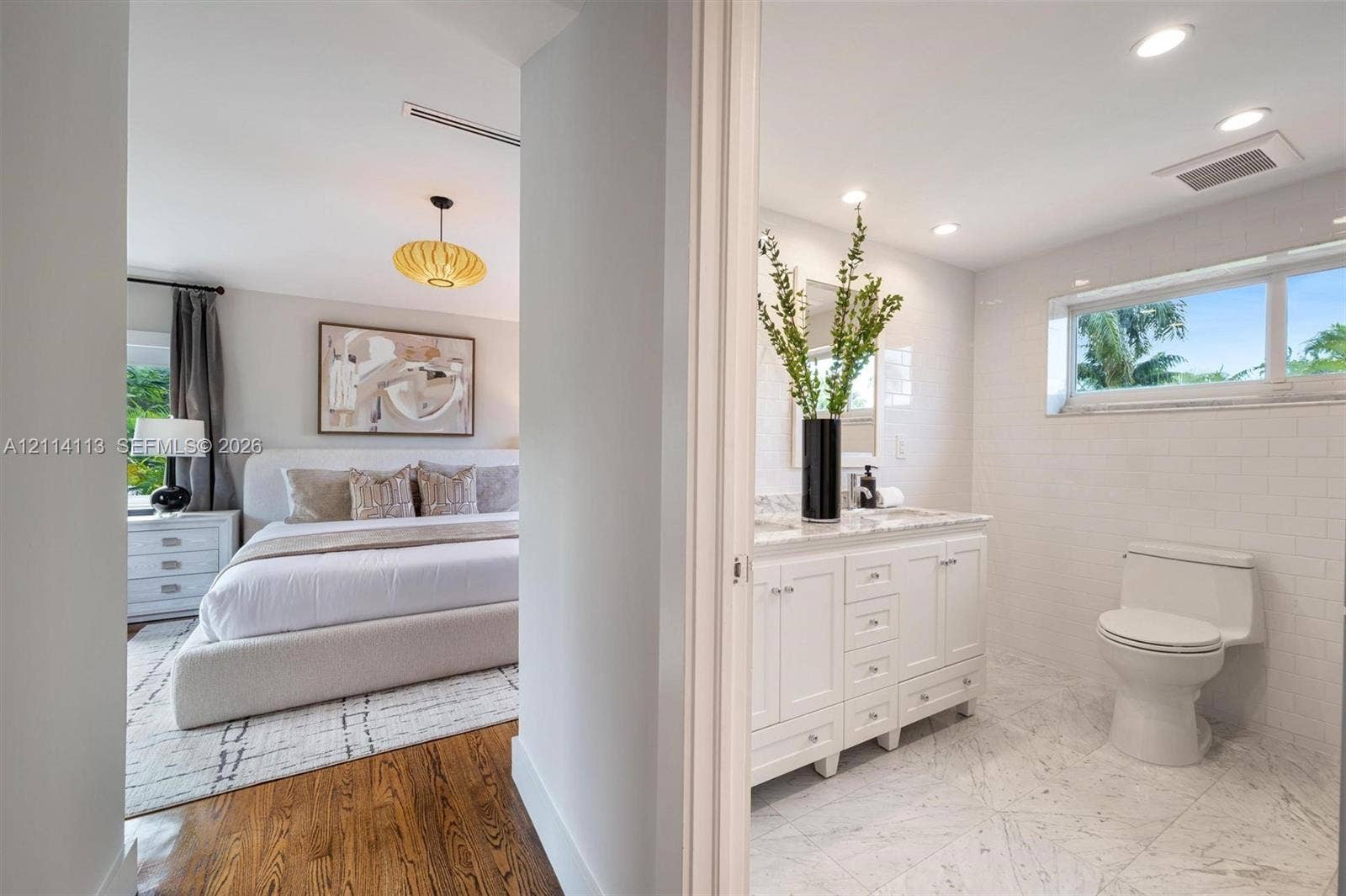 5386 Alton Road, Miami Beach, FL 33140 Bathroom featuring a white vanity with a marble countertop, white subway tile wall accents, and stone-finish floor tiling