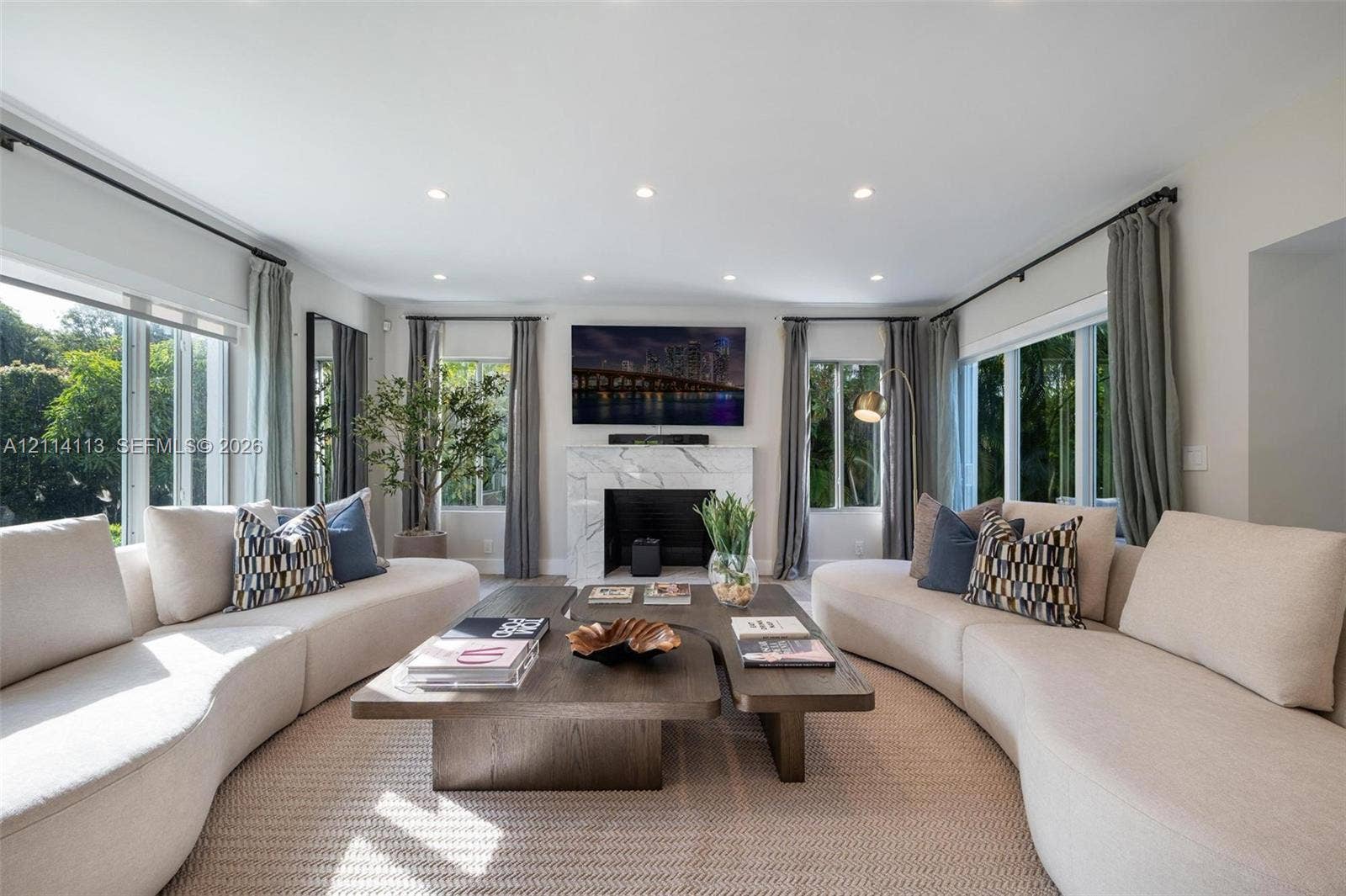 5386 Alton Road, Miami Beach, FL 33140 Living room featuring a stone-surround fireplace, multi-pane windows, recessed lighting, and wall-to-wall flooring