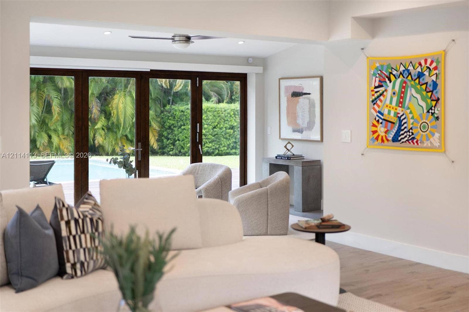 5386 Alton Road, Miami Beach, FL 33140 Multi-panel dark-finish sliding glass doors, recessed lighting, ceiling fan, and wood-finish flooring