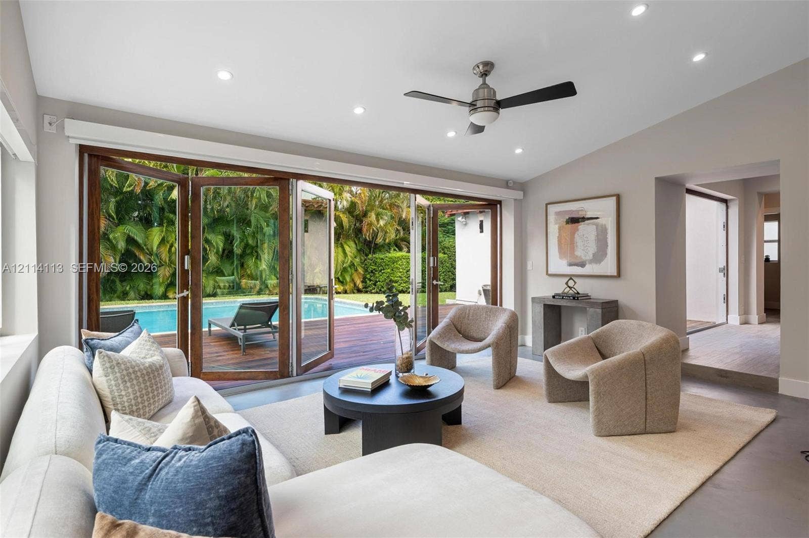 5386 Alton Road, Miami Beach, FL 33140 Multi-panel folding glass doors, recessed lighting, ceiling fan, neutral wall palette, and polished concrete flooring