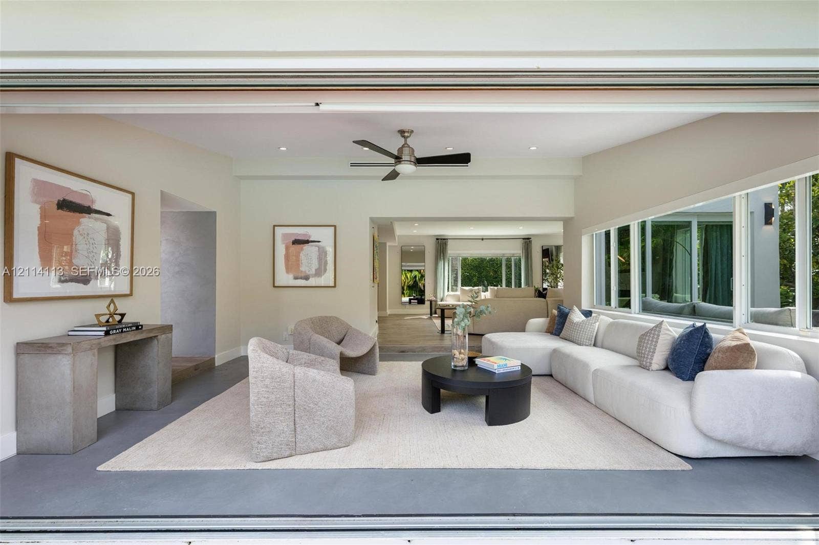 5386 Alton Road, Miami Beach, FL 33140 Open-concept interior featuring large-format retractable glass walls, recessed lighting, ceiling fan, and painted walls