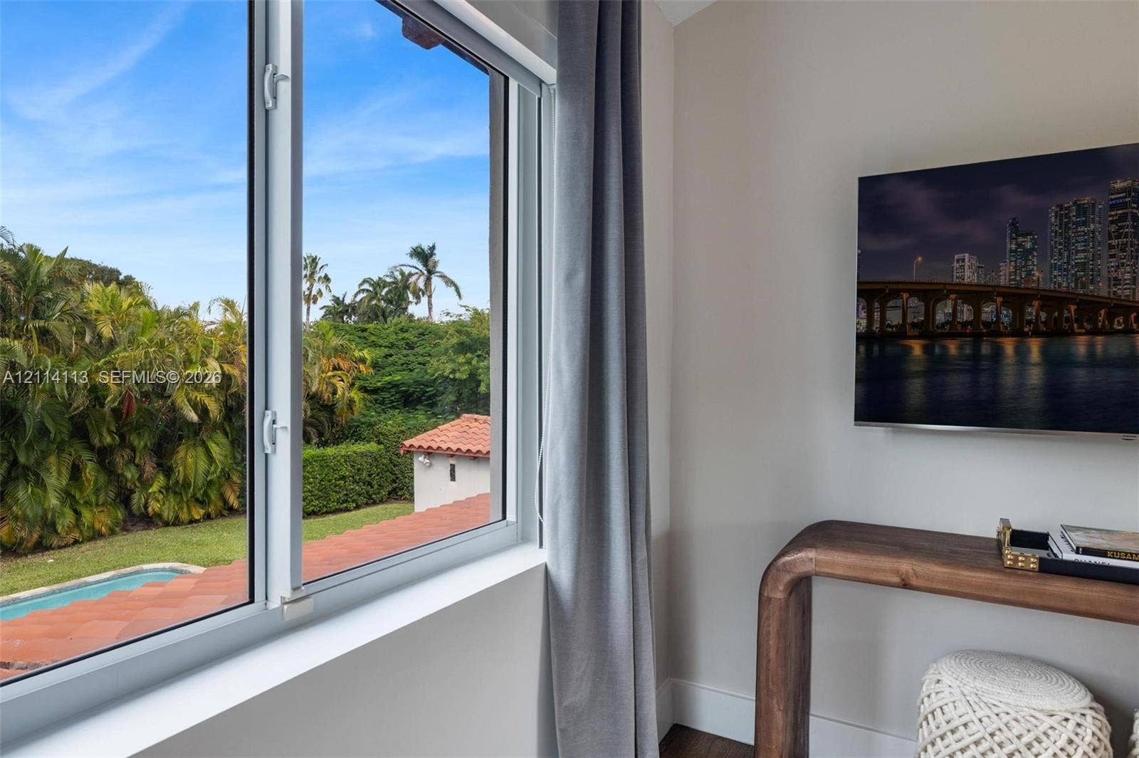 5386 Alton Road, Miami Beach, FL 33140 Casement window featuring white frames and custom wall-mounted television