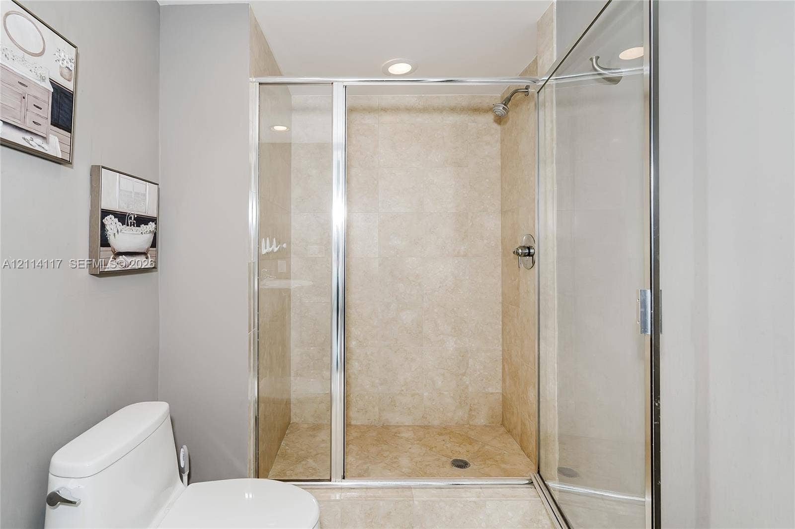 1850 S Ocean Drive, #4008, Hallandale Beach, Hallandale Beach, FL 33009 Walk-in shower featuring tile surrounds, chrome fixtures, and a glass enclosure, complemented by a white porcelain toilet