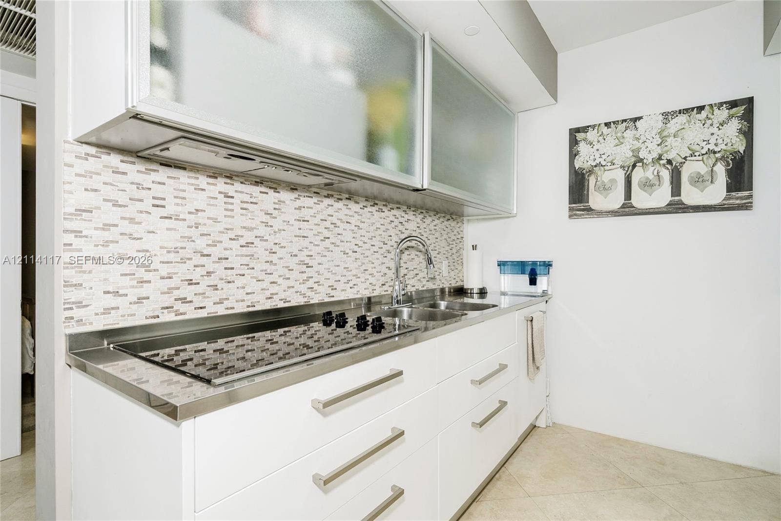 1850 S Ocean Drive, #4008, Hallandale Beach, Hallandale Beach, FL 33009 Kitchen featuring white flat-panel cabinetry, frosted glass upper cabinet doors, mosaic tile backsplash, integrated stainless steel cooktop, and metal hardware