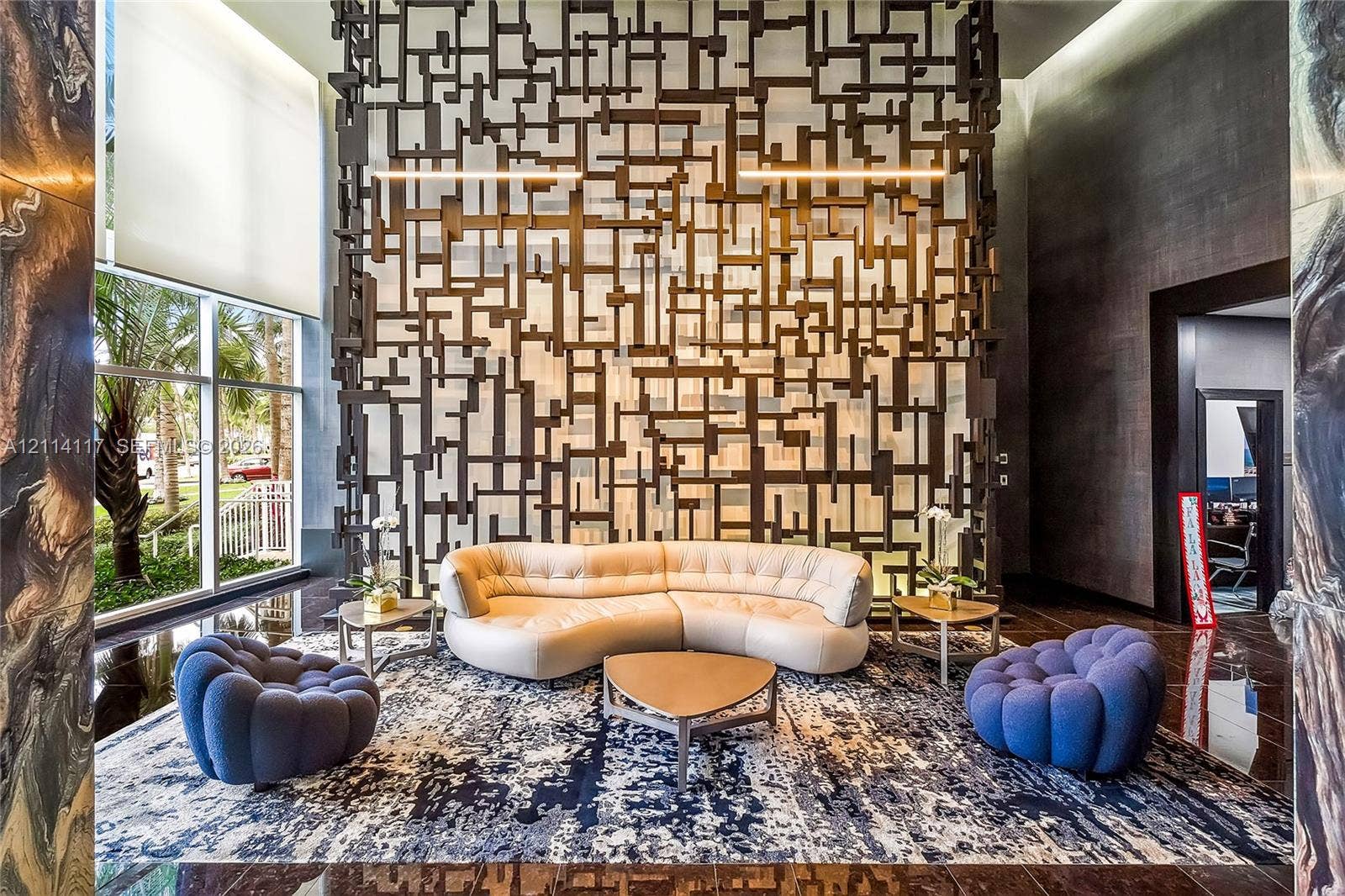 1850 S Ocean Drive, #4008, Hallandale Beach, Hallandale Beach, FL 33009 Lobby featuring a double-height ceiling, floor-to-ceiling windows, polished stone flooring, and a large-scale decorative geometric metal partition wall