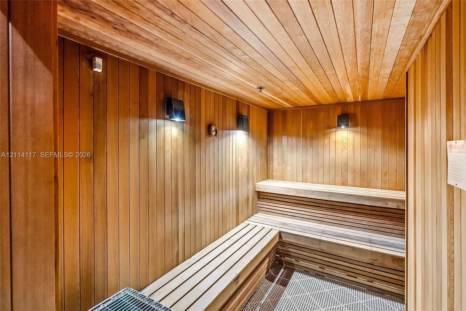 1850 S Ocean Drive, #4008, Hallandale Beach, Hallandale Beach, FL 33009 Sauna featuring natural wood tongue-and-groove wall and ceiling paneling, multi-level slatted wood benches, recessed wall-mounted sconce lighting, and a metal heating unit