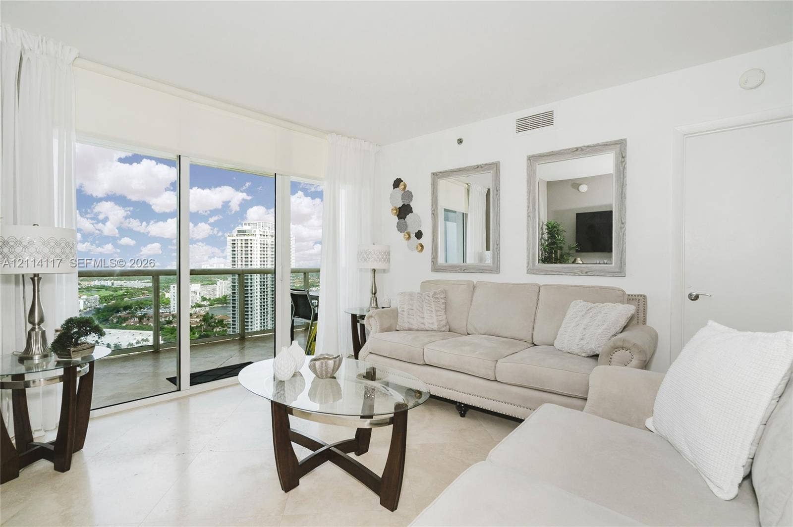 1850 S Ocean Drive, #4008, Hallandale Beach, Hallandale Beach, FL 33009 Living area featuring floor-to-ceiling glass sliding doors, stone-finish flooring, and a private balcony with glass railing