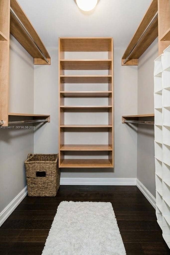 1850 S Ocean Drive, #4008, Hallandale Beach, Hallandale Beach, FL 33009 Walk-in closet featuring wood-finish shelving, integrated hanging rods, and dark-toned wood-finish flooring