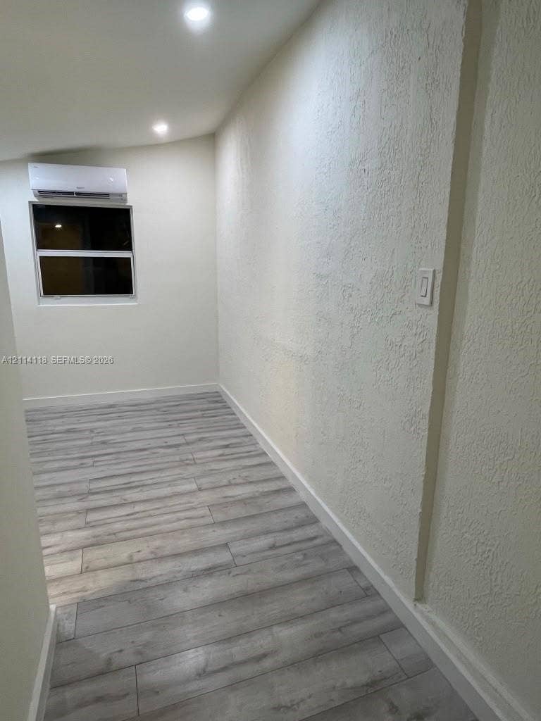 2484 SW 10th Street, #4 - eff, Miami, Miami, FL 33135 Room interior featuring wood-finish flooring, recessed lighting, and a wall-mounted ductless air conditioning unit