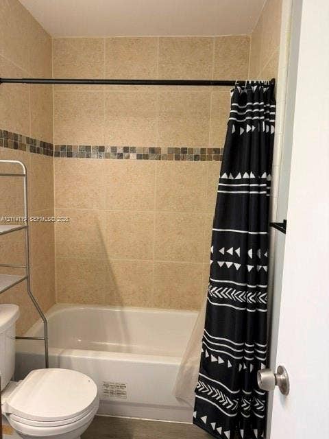 Bathtub with white surround and neutral wall tile featuring a decorative mosaic accent border